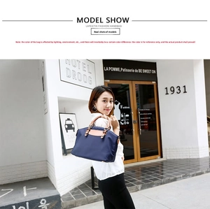 Detailed view of navy blue oxford tote with brown leather handles worn by a model