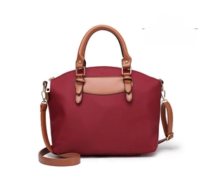 Front view of red oxford fabric tote bag with brown handles and golden hardware