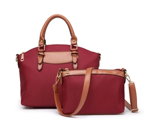 Detailed view of burgundy nylon handbag set with brown leather straps and gold hardware