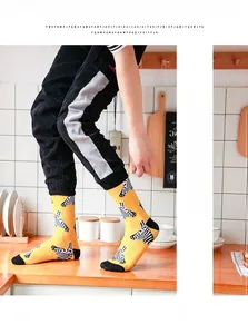 Detailed close-up of yellow crew socks with zebra print and black reinforced heel