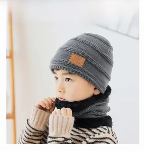 Detail of children's grey knit hat with thick plush lining and leather patch detail