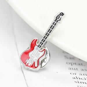 Macro shot of an electric guitar brooch with red and white enamel on silver metal