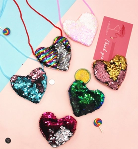 Flat lay of colorful heart-shaped sequin crossbody purses for kids in various shades