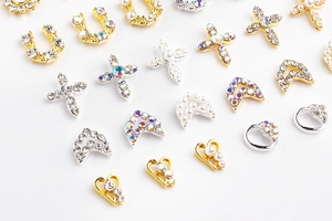 Detailed view of alloy nail charms with rhinestones and pearls in gold and silver