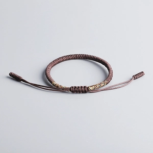 Macro shot of handcrafted brown woven knot bracelet with colorful closure details