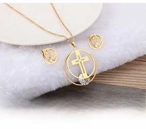 Macro view of gold-plated necklace and earrings set with hollow cross and zircons