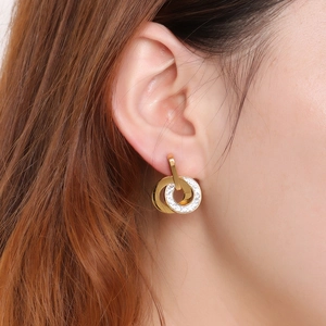 Golden double hoop interlocking earrings with sparkling crystals worn by a model