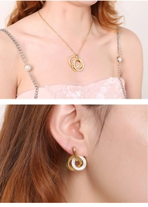 Detail view of gold interlocking double rings necklace and earrings set with zircons