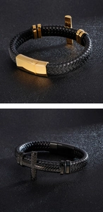 Detail of woven leather bracelets with cross charms in gold and black metal finishes