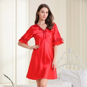 Close-up of red silk satin pajamas featuring delicate black lace trim on the V-neckline