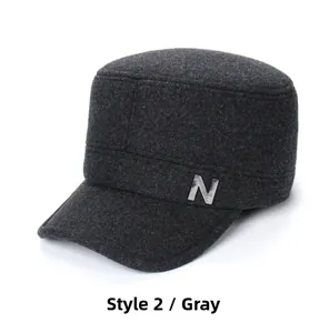 Detail of charcoal wool flat top military cap featuring a silver metal N accent decoration