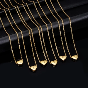 Golden stainless steel heart pendant necklaces with laser engraved letters on black background