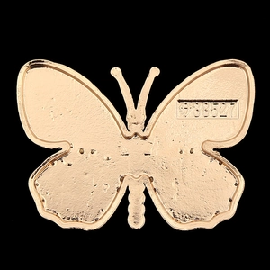 Golden butterfly metal accessory with textured finish and engraved 38527 numeric detail
