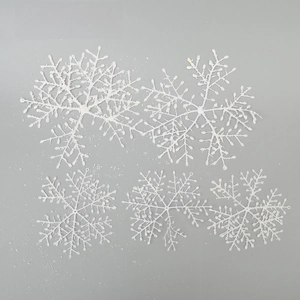 Macro detail of white glitter snowflake decorations for Christmas window displays