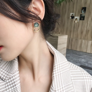 Vintage green round studs with layered gold metal rings shown on a model