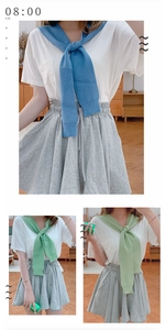 Detail of blue and green knitted shawl wraps tied over a white shirt for layering