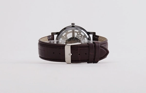 Macro view of watch case back showing transparent mechanical movement and brown leather strap