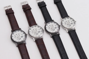 Detailed view of men's skeleton quartz watches with black and brown leather straps