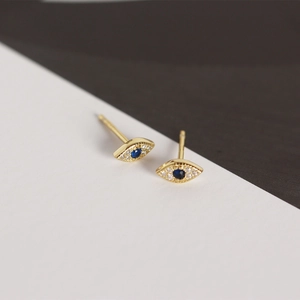 Macro shot of 925 silver devil eye stud earrings with blue stone and sparkling zircon