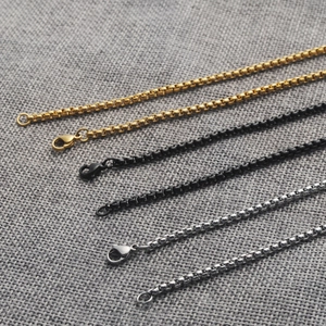 Three box chain necklaces in gold, black, and silver stainless steel with lobster clasps