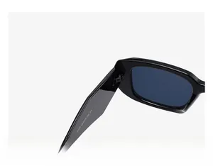 Detail view of reinforced hinge and size specs on black frame sunglasses with blue lenses