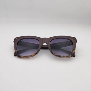 Detail of oversized sunglasses with burgundy tortoiseshell frames and gradient lenses
