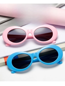 Detail of trendy oval sunglasses in pink and blue frames with dark UV lenses