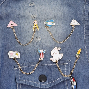 Detail of artistic metal enamel pin sets featuring creative designs on denim fabric