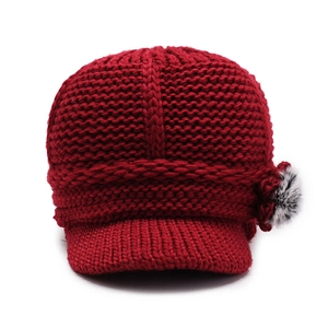 Women's knit brimmed hat in deep red with faux fur pom pom and floral detail