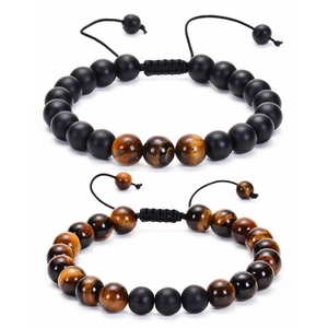 Close-up of matte black beads and red tiger eye stone bracelets with adjustable cords