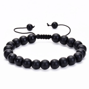 Detail of matte black stone beaded bracelet with adjustable hand-woven cord closure