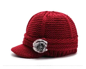 Side view of dark red chunky knit visor beanie with leopard faux fur pom-pom detail