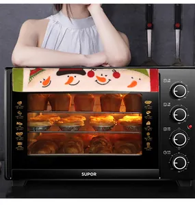 Close-up of a black oven featuring a Christmas snowman handle cover and baked tarts inside