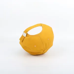 Detail view of yellow canvas baseball cap with white stitching and metal buckle
