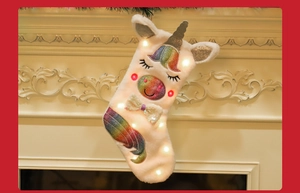 Detail view of plush unicorn Christmas stocking with rainbow sequins and glowing LED lights