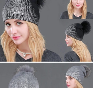 Detailed close-up of gradient knit beanie with large fluffy raccoon fur pompom detail