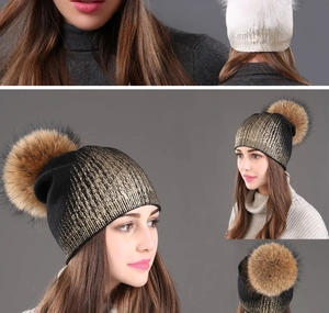 Detail view of winter knit beanie with metallic gold foil print and large faux fur pom-pom