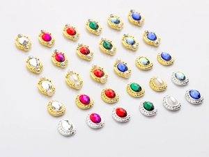 Macro shot of oval vintage alloy rhinestones with pearls in emerald, red and blue