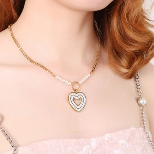 Elegant gold necklace with heart pendant, white pearls and clear rhinestones on a model