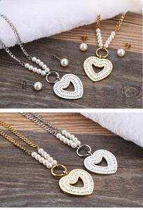 Detailed view of heart-shaped pendant necklace and pearl earrings set in gold and silver