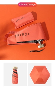 Detail of vibrant orange mini sun umbrella with black UV coating and matching case
