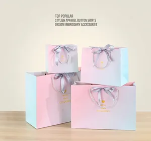 Detail of gradient gift bags with golden heart icons and elegant ribbon handles