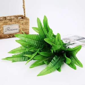 Close-up of green artificial Boston fern leaves with realistic textures in a woven basket