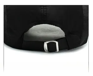 Detail of breathable mesh fabric and adjustable silver metal buckle on black baseball cap