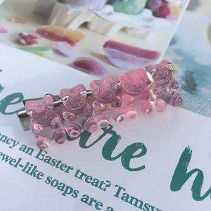 Detail view of pink resin jelly bear hair clips with a silver metal alligator base