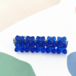 Detail of blue candy bear hair clip with five transparent resin bears on a metal base