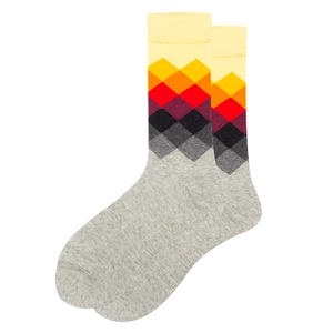 Detail of grey cotton crew socks featuring vibrant yellow and red geometric diamond patterns