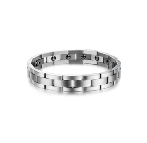 Macro detail of silver magnetic therapy bracelet showing black health elements and link metal