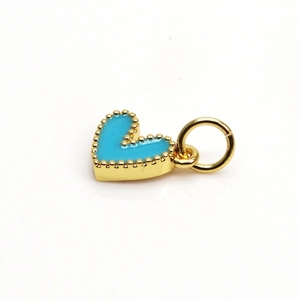 Macro shot of sky blue heart pendant with gold beaded edges and enamel finish