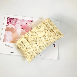 Handmade corn husk straw clutch bag with natural woven pattern for summer beach use